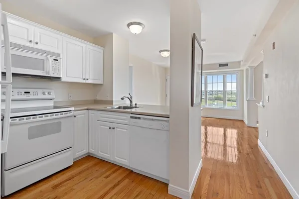 a kitchen with granite countertop white cabinets and white appliances