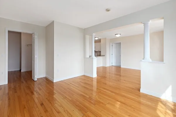 a view of empty room with wooden floor
