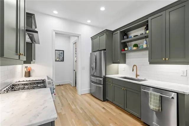 a kitchen with stainless steel appliances granite countertop a sink stove and refrigerator