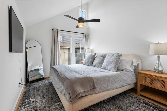 a bedroom with a bed wooden floor and a rug