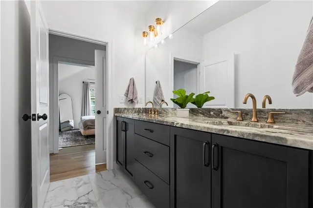a bathroom with a granite countertop sink and a mirror