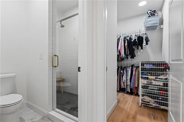 a view of walk in closet with clothes and shoes