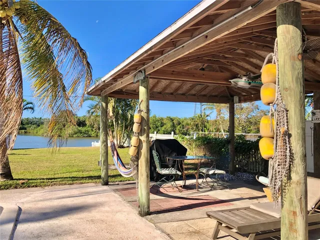 a view of backyard with a table and chairs under an umbrella