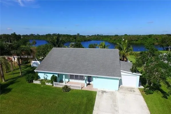 an aerial view of a house with a garden and trees
