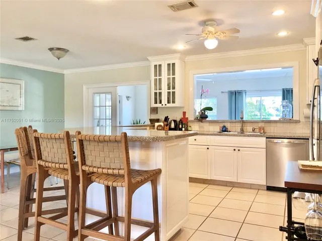 a kitchen with granite countertop cabinets and chairs