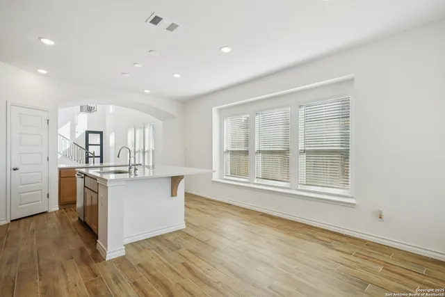 a kitchen with stainless steel appliances granite countertop a stove and a large window