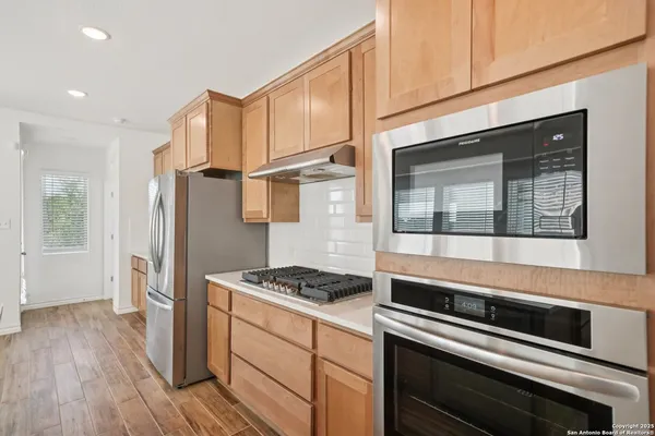 a kitchen with stainless steel appliances granite countertop a stove and a refrigerator