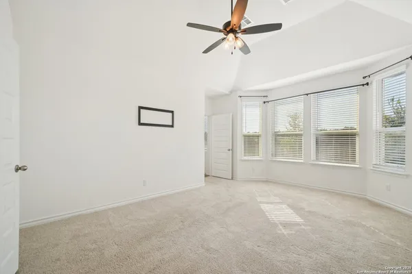an empty room with windows and fan