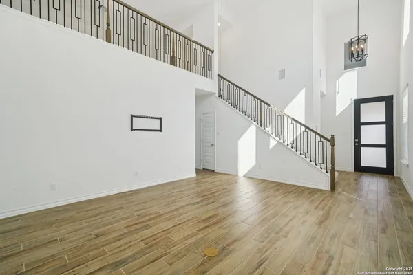 a view of a hallway with wooden floor and staircase