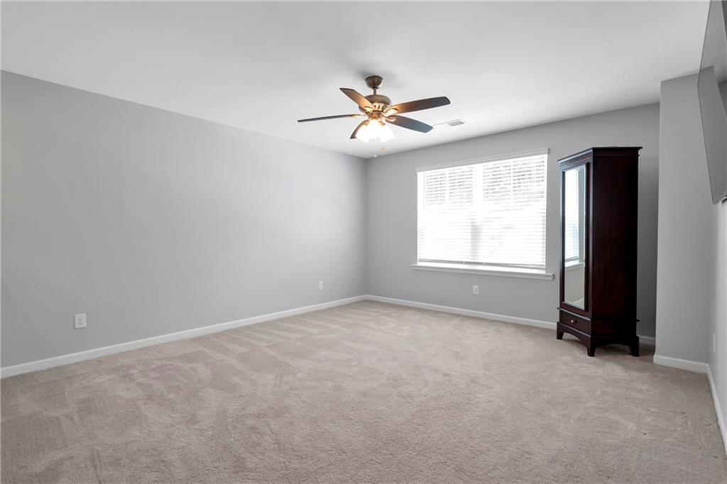 660 Groover Street Ball Ground, GA 30107 - Photo 22 of 53 an empty room with windows and fan