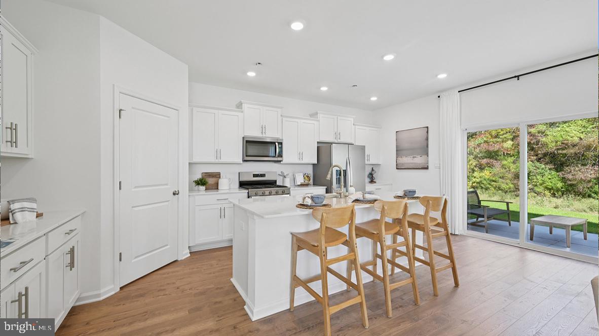 505 Scotty Boulevard, Unit 1302 Rio Grande, NJ 08242 - Photo 17 of 55 a kitchen with stainless steel appliances kitchen island granite countertop a stove top oven a sink a refrigerator with white cabinets and wooden floor