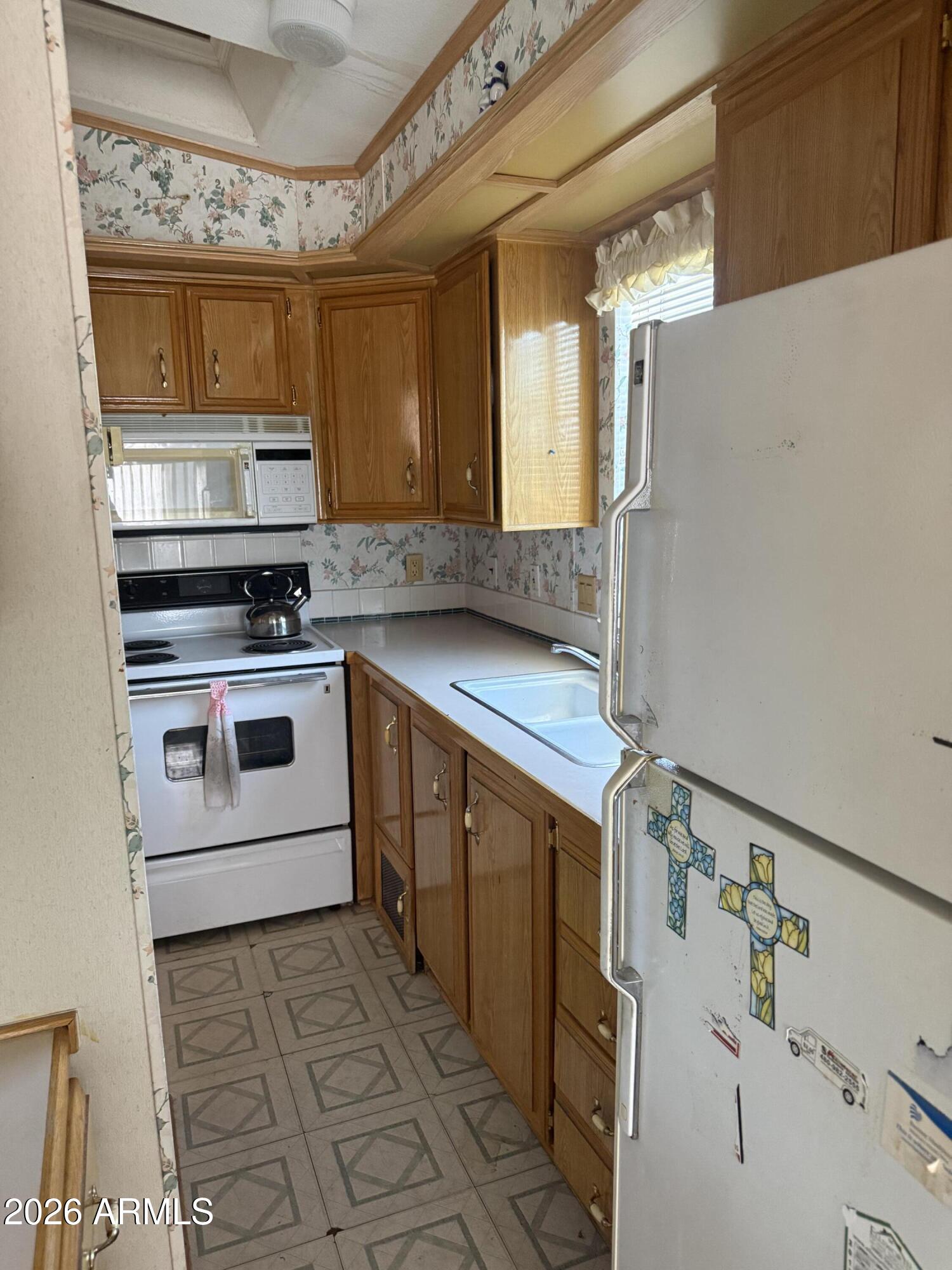 7750 East Broadway Road, Unit 406 Mesa, AZ 85208 - Photo 6 of 36 a kitchen with stainless steel appliances a stove a sink and a refrigerator