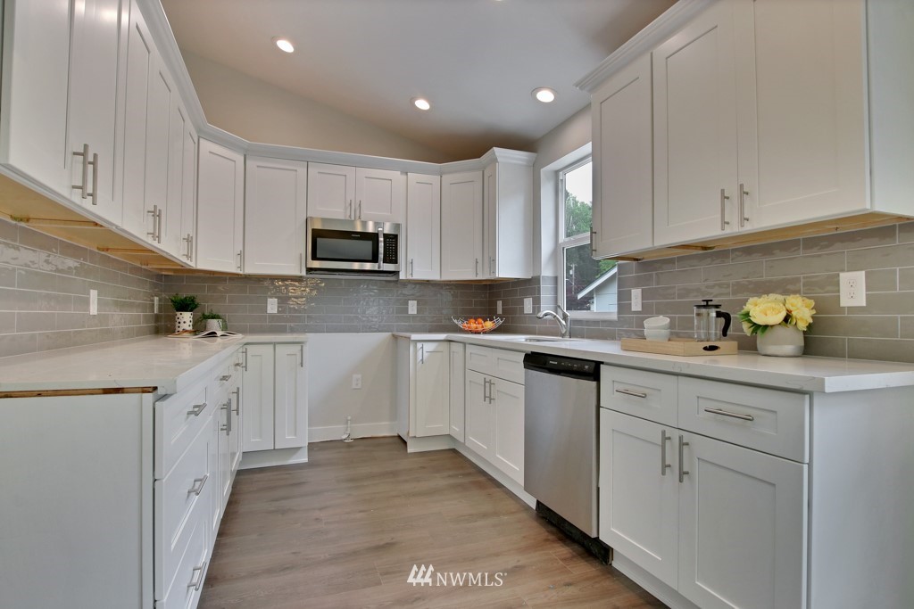 3116 Southeast 6th Street Renton, WA 98058 - Photo 11 of 20 a kitchen with granite countertop white cabinets sink and stainless steel appliances