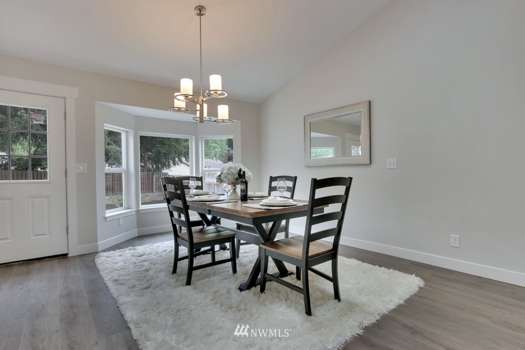 3116 Southeast 6th Street Renton, WA 98058 - Photo 7 of 20 a dining room with wooden floor a chandelier a wooden table and chairs