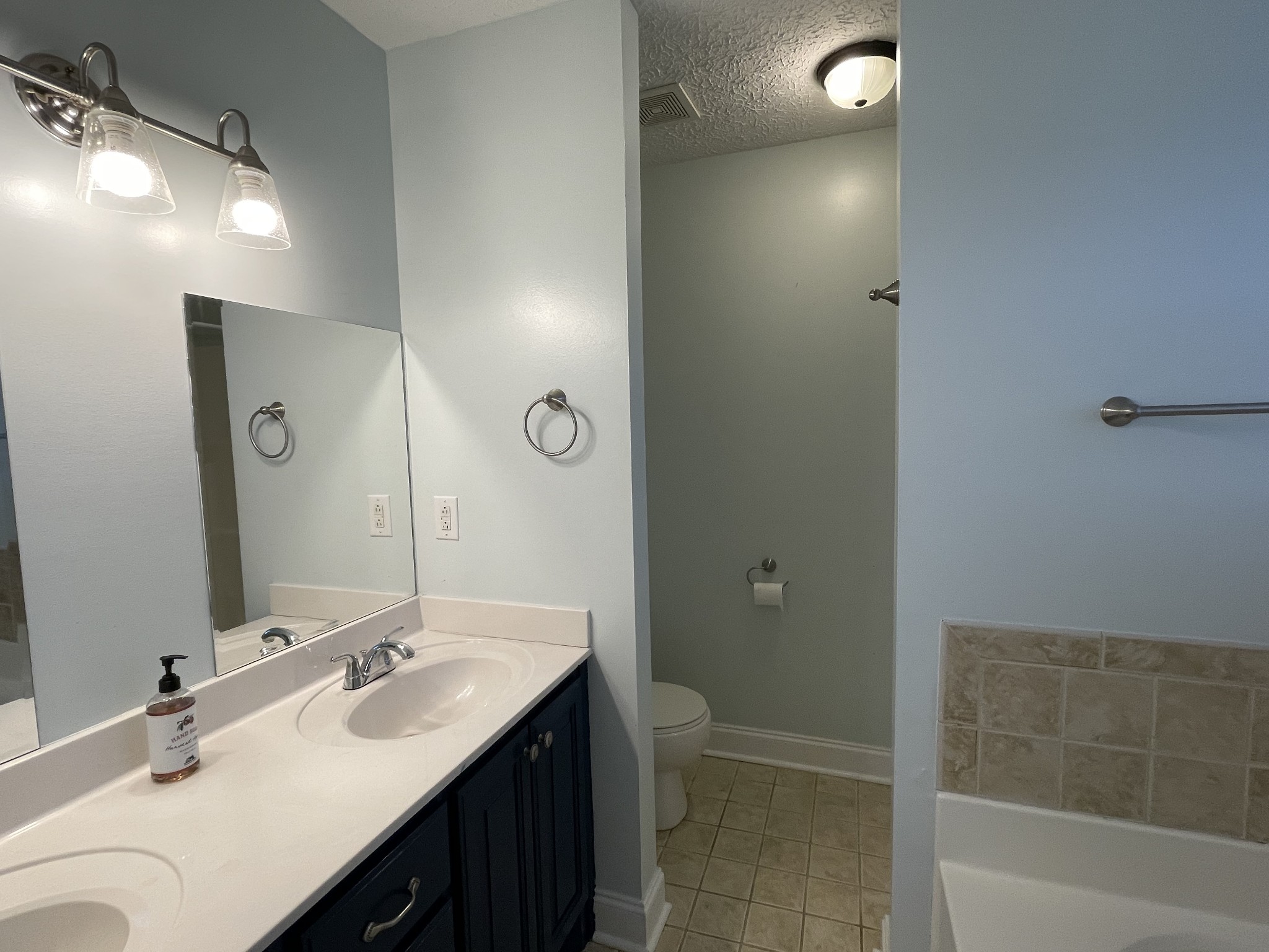 5235 Youngville Road Springfield, TN 37172 - Photo 23 of 28 a bathroom with a double vanity sink a toilet and shower
