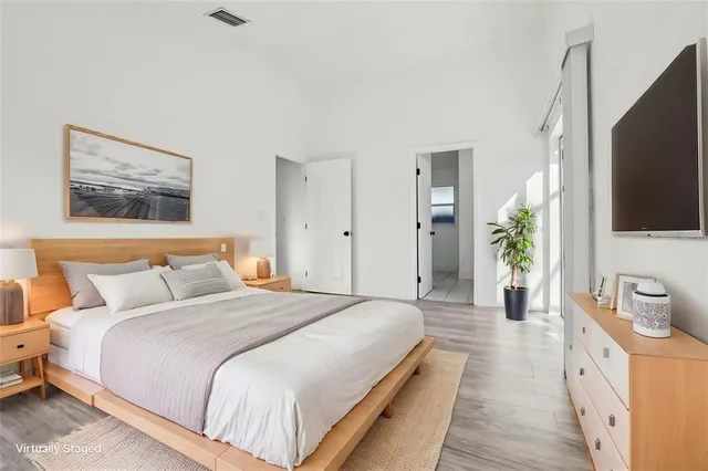 a spacious bedroom with a bed and a flat screen tv