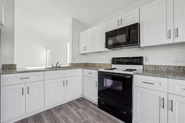 a kitchen with white cabinets stainless steel appliances and sink
