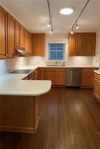 a kitchen with granite countertop a sink cabinets and wooden floor