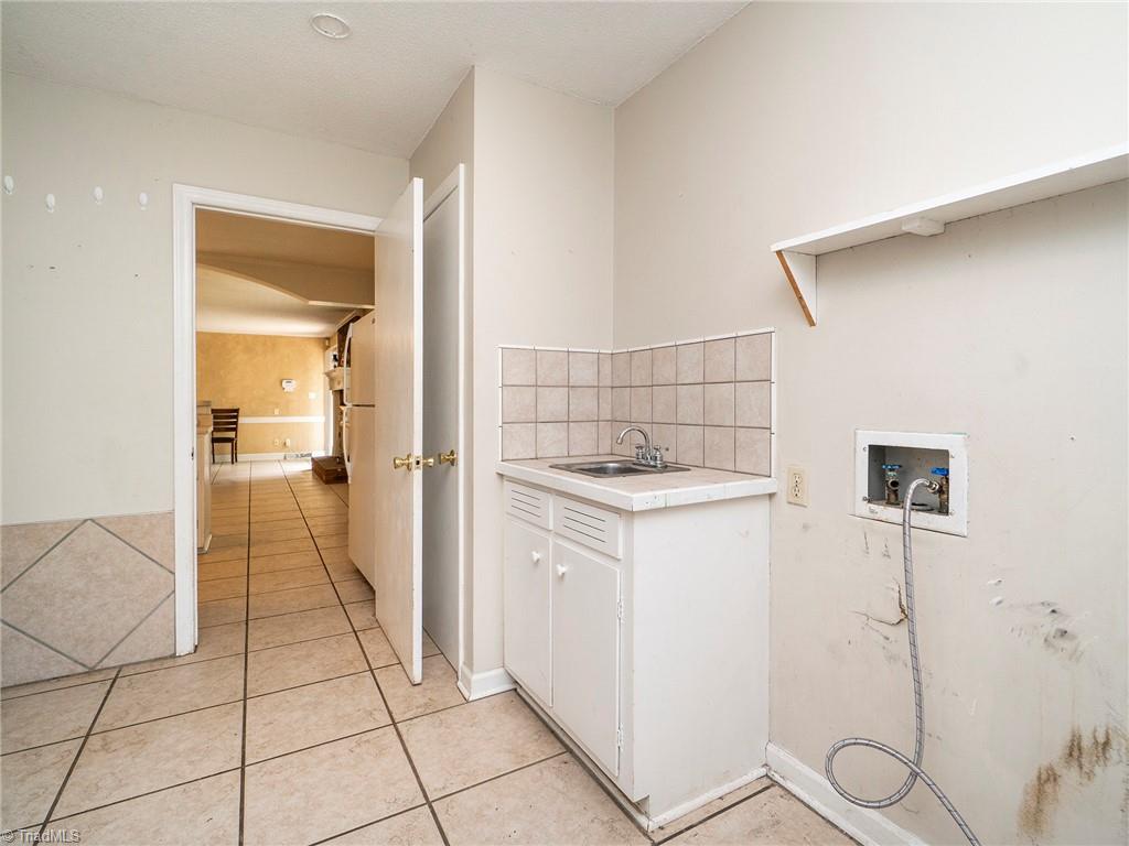 5531 Davis Road Walkertown, NC 27051 - Photo 12 of 30 Laundry room with sink and doorway leading to the carport