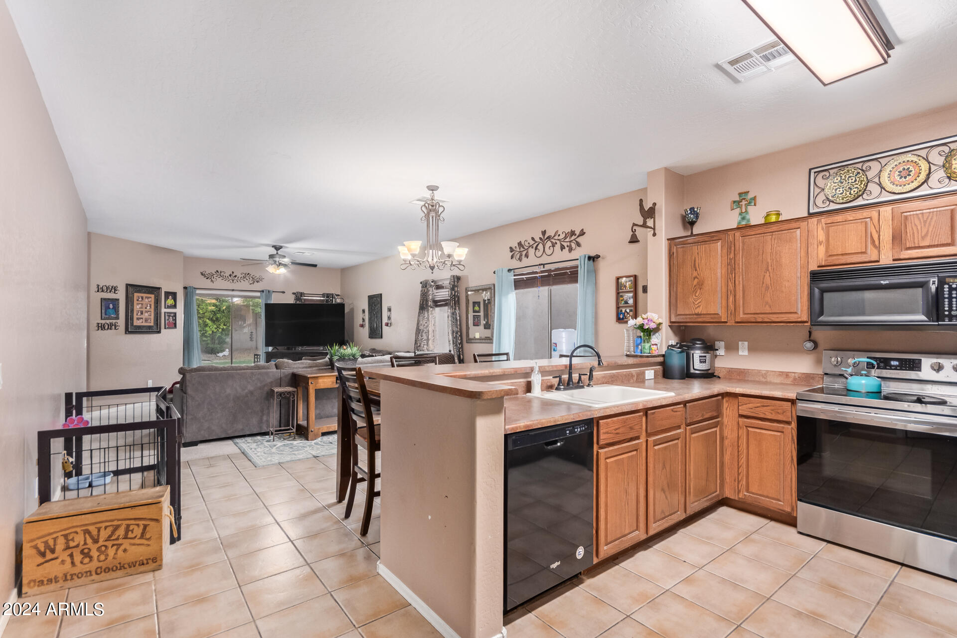 321 East Cheyenne Road San Tan Valley, AZ 85143 - Photo 20 of 33 a kitchen with stainless steel appliances a stove a sink a oven a dining table and chairs