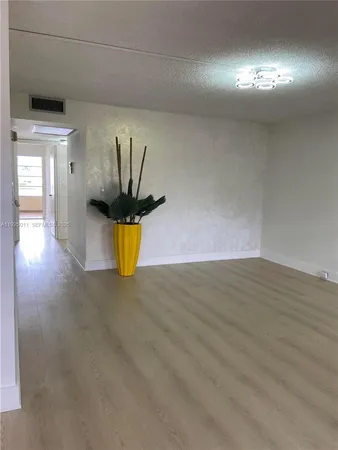 a view of a room with wooden floor and window