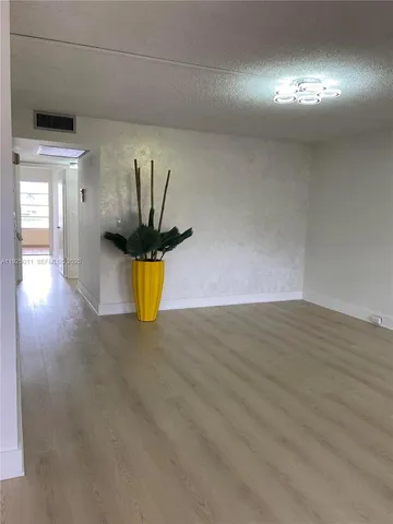 a view of a room with wooden floor and window