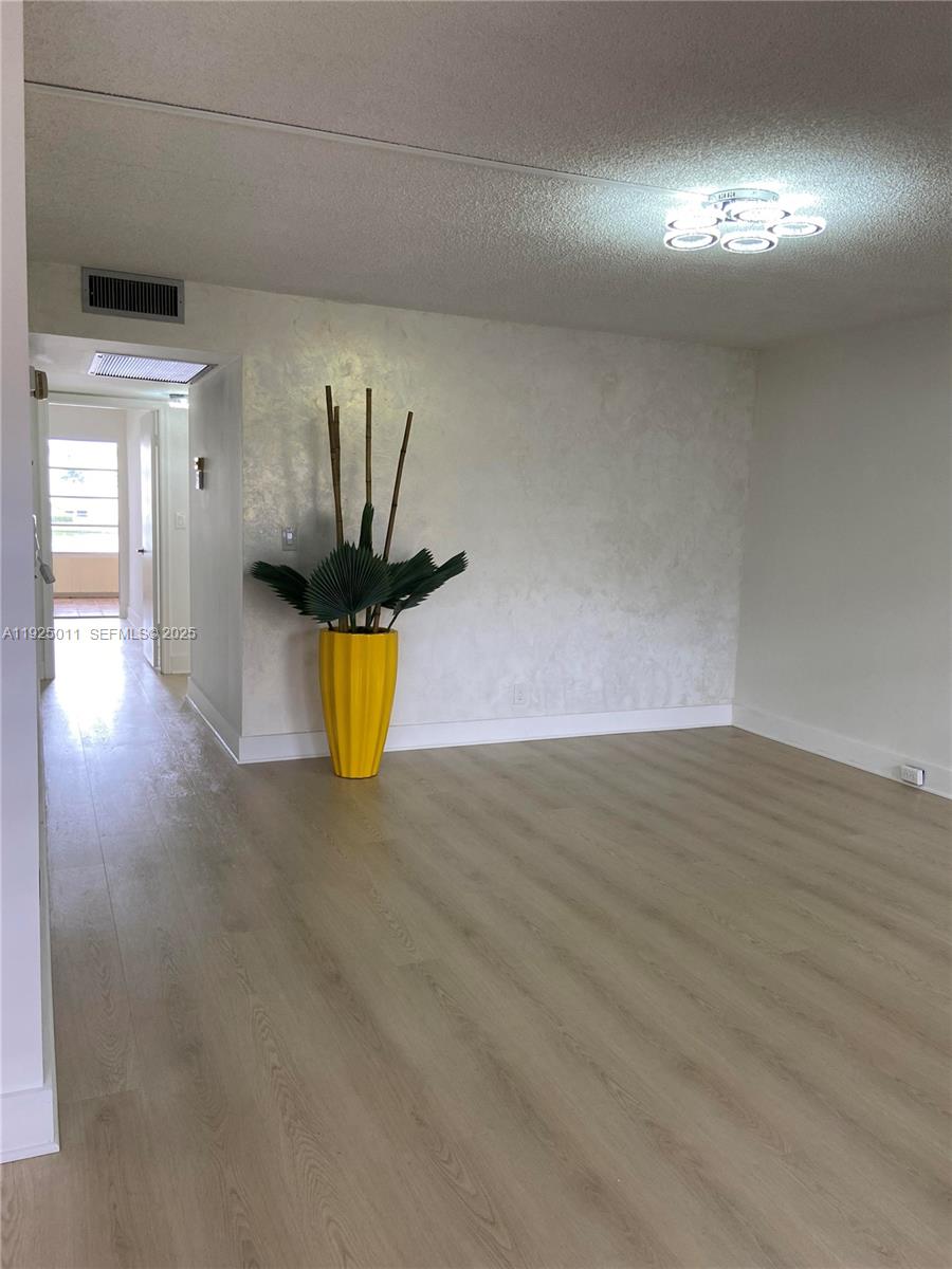 a view of a room with wooden floor and window