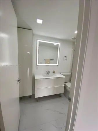 a bathroom with a double vanity sink toilet and shower