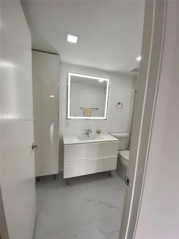 a bathroom with a double vanity sink toilet and shower
