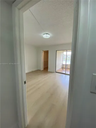 an empty room with windows and ceiling fan