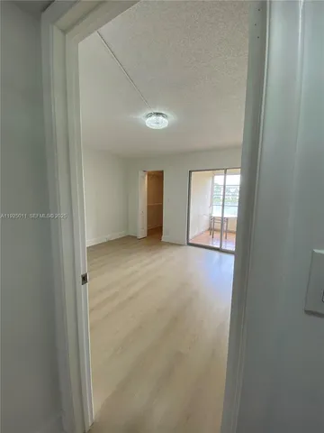 an empty room with windows and ceiling fan