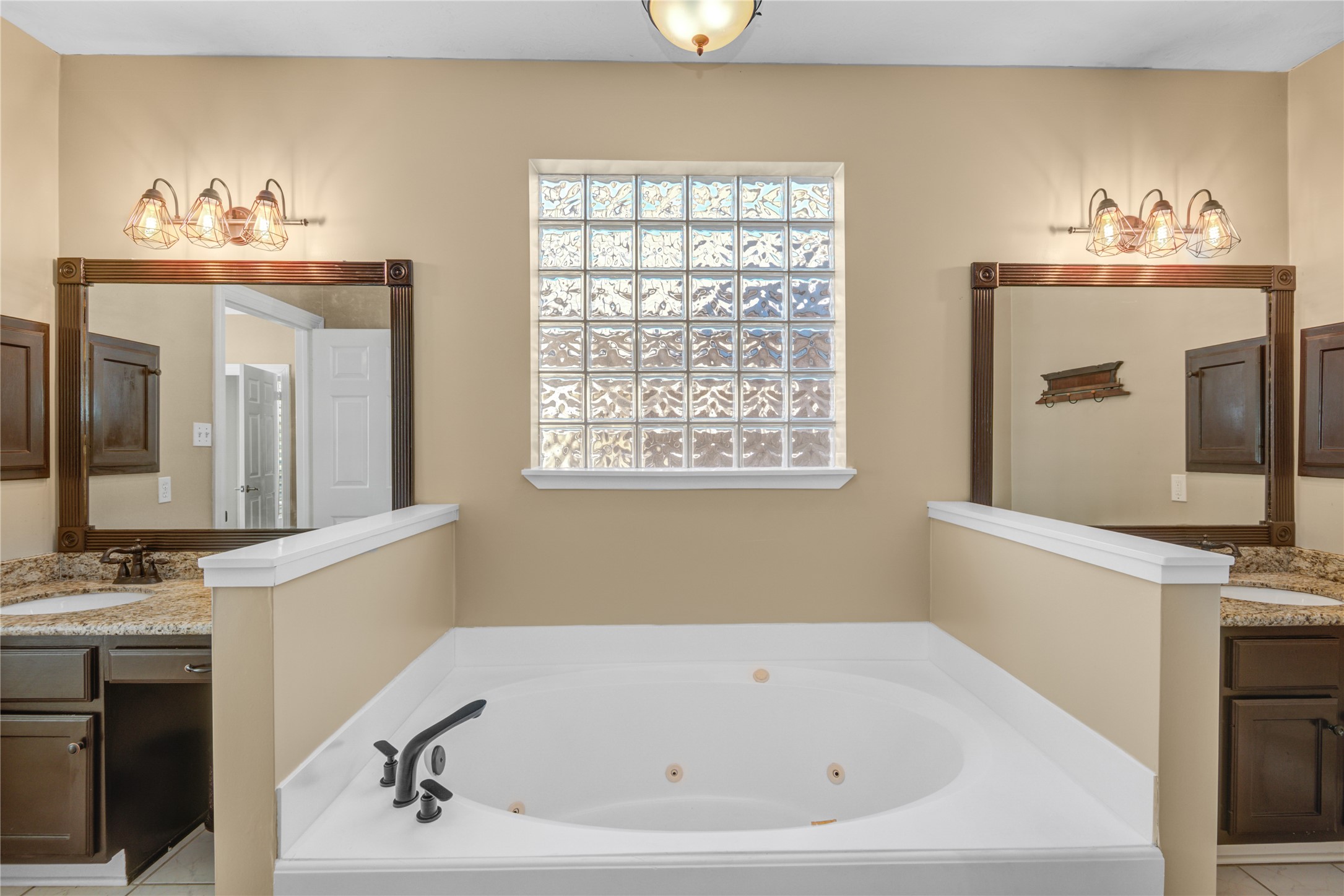 13215 Jessica Lane Houston, TX 77069 - Photo 17 of 33 The primary bathroom includes dual vanities and a jetted tub designed for everyday use.