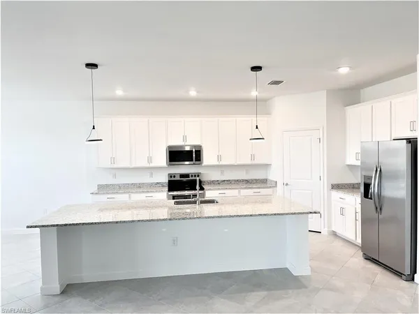 a kitchen with stainless steel appliances a refrigerator sink and microwave