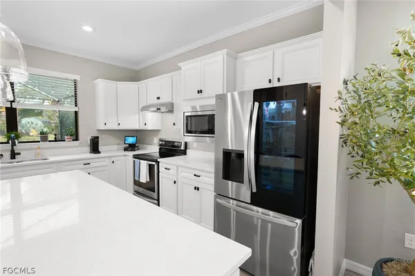 a kitchen with white cabinets and stainless steel appliances