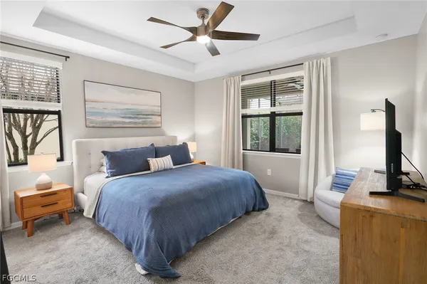a bedroom with a large bed and a flat tv screen on dresser