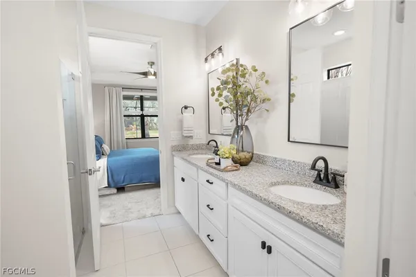 a bathroom with a granite countertop sink a mirror and shower