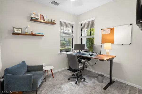 a view of a workspace with furniture and a window