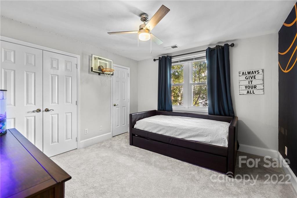 166 Lake Pointe Drive Fort Mill, SC 29708 - Photo 35 of 42 a bedroom with a large bed and a chandelier