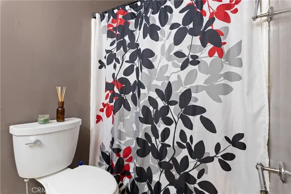 a white toilet sitting next to a shower curtain