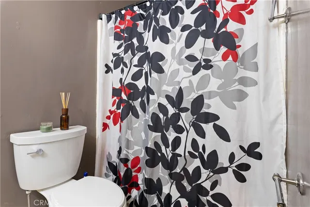 a white toilet sitting next to a shower curtain