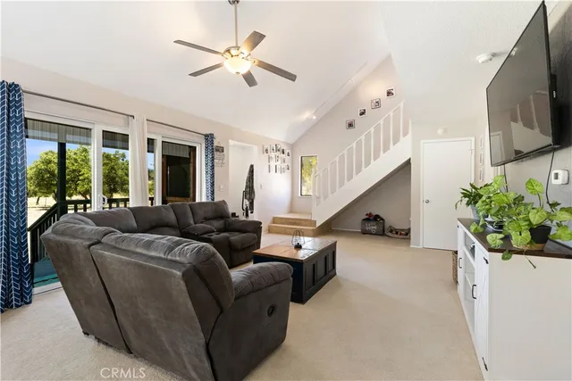 a living room with furniture ceiling fan and a flat screen tv