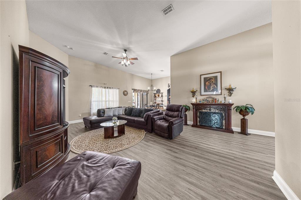 4590 Southwest 111th Place Ocala, FL 34476 - Photo 11 of 36 a living room with furniture a fireplace and a flat screen tv