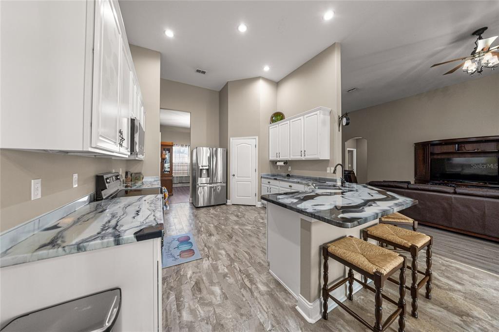 4590 Southwest 111th Place Ocala, FL 34476 - Photo 15 of 36 a kitchen with a stove a sink and a refrigerator