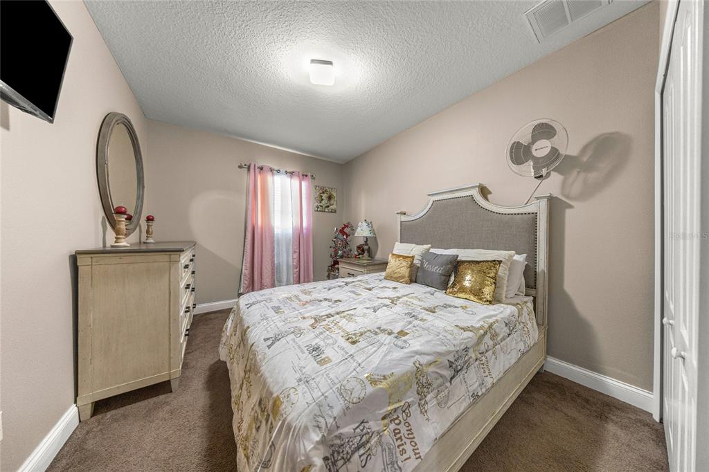 4590 Southwest 111th Place Ocala, FL 34476 - Photo 24 of 36 a bedroom with a bed and a flat screen tv