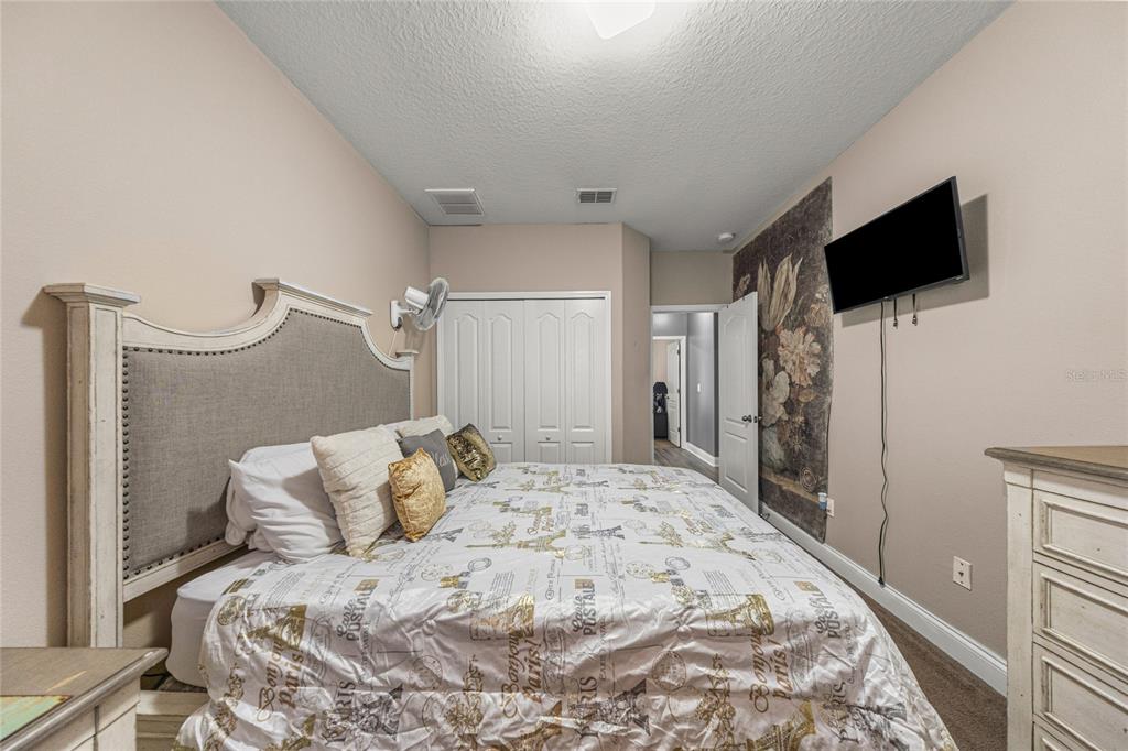 4590 Southwest 111th Place Ocala, FL 34476 - Photo 25 of 36 a bedroom with a bed and a flat screen tv