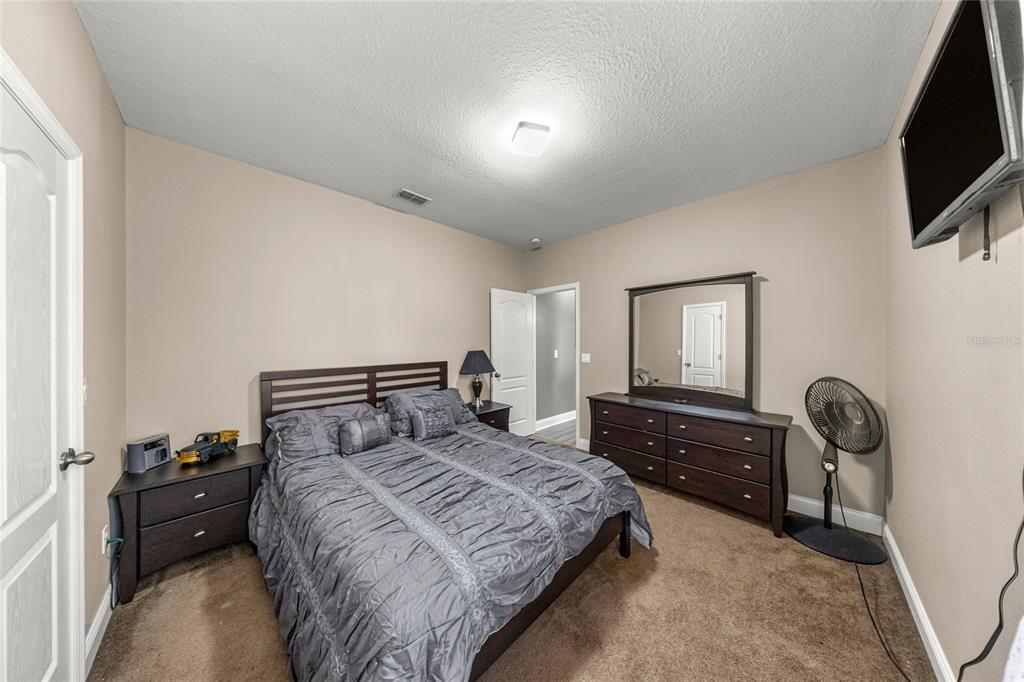 4590 Southwest 111th Place Ocala, FL 34476 - Photo 27 of 36 a bedroom with a bed and a tv on dresser