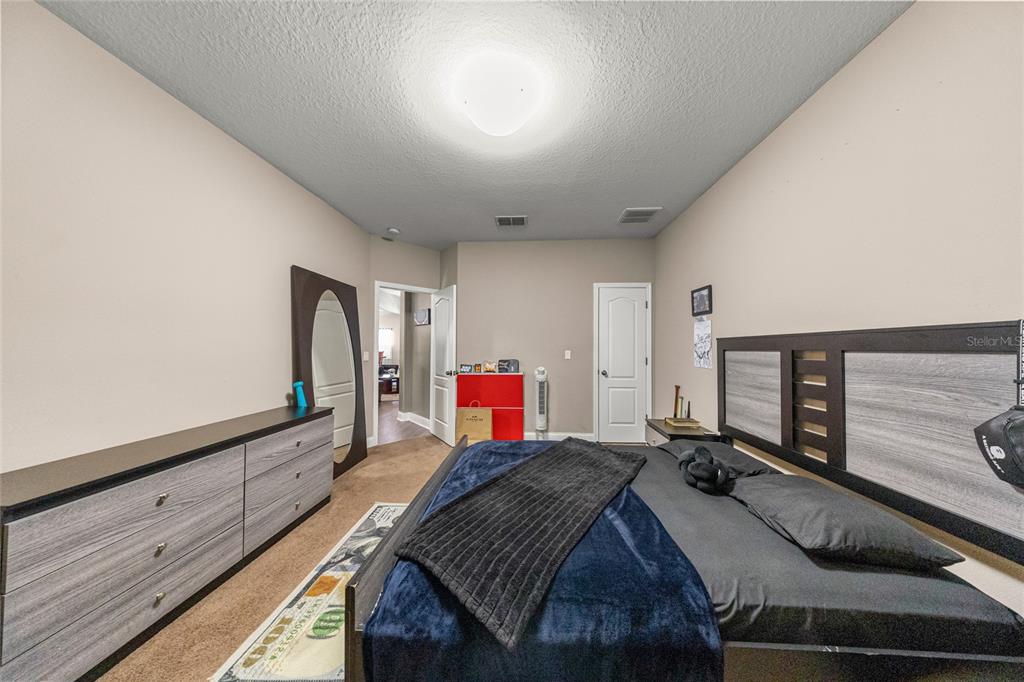 4590 Southwest 111th Place Ocala, FL 34476 - Photo 30 of 36 a bedroom with a bed and a dresser