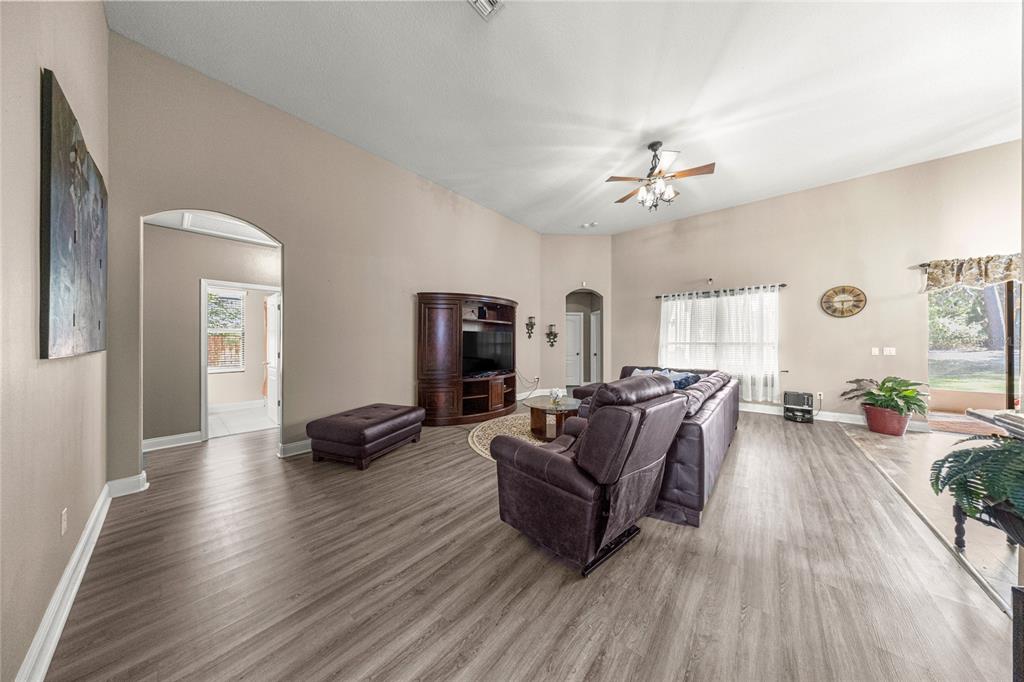 4590 Southwest 111th Place Ocala, FL 34476 - Photo 10 of 36 a living room with furniture a ceiling fan and a wooden floor