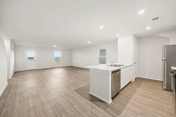 a view of a kitchen with wooden floor and electronic appliances