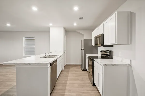 a kitchen with white cabinets sink and stainless steel appliances